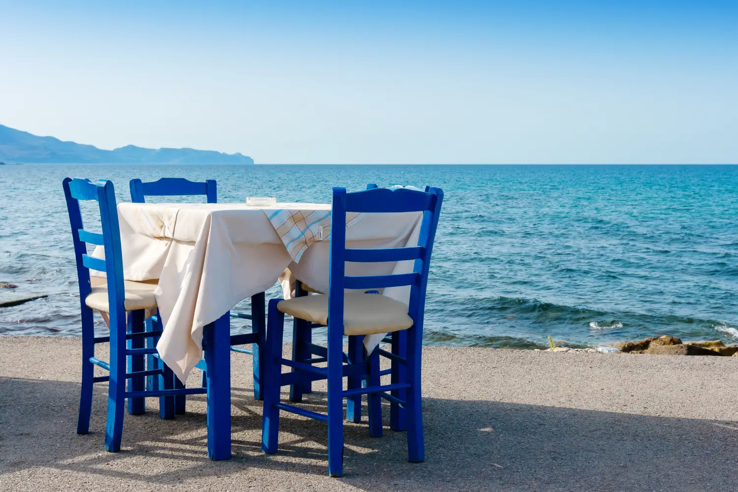 Ferry to Kissamos - Table and chairs in sidewalk cafe at Kissamos, Crete, Greece.