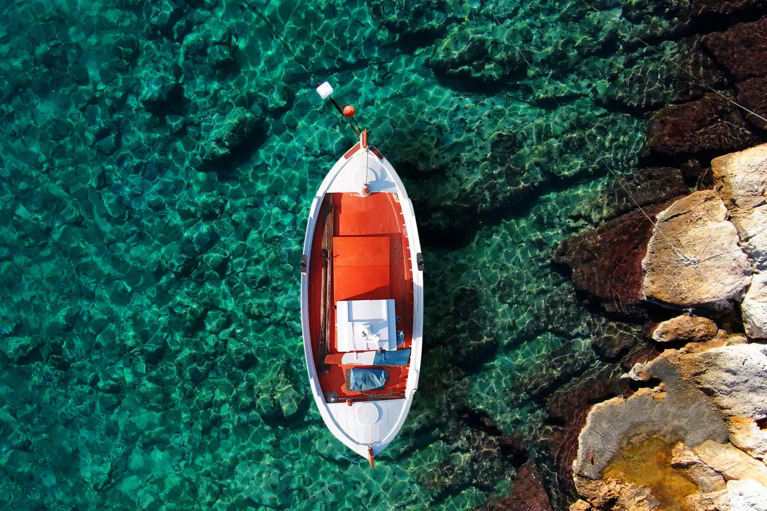Ferry to Iraklia - Aerial top view photo of traditional fishing boat from famous small port in island of Irakleia with emerald clear waters, Cyclades, Greece.