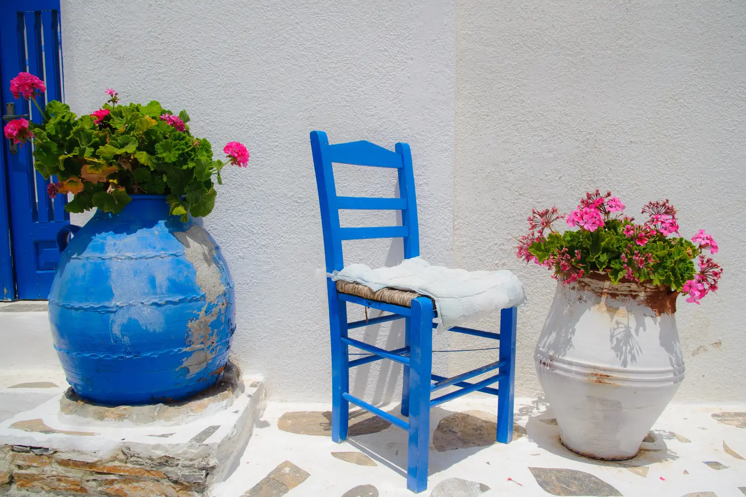 Ferry to Schinoussa - Traditional greek blue chair together with flower pots.