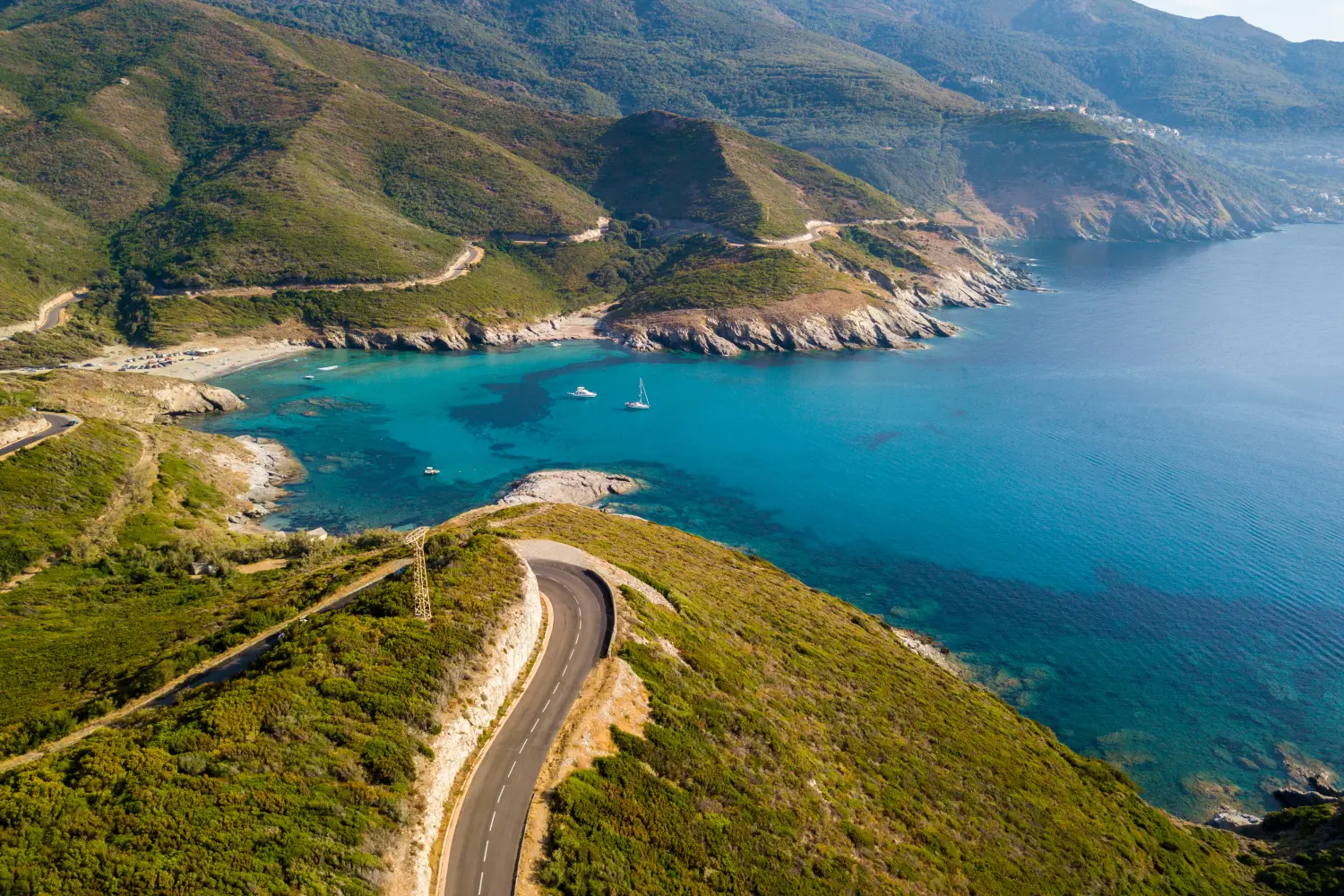 Ferry to Corsica - Aerial view of the coast of Corsica, winding roads and coves with crystalline sea Cap Corse Peninsula, Corsica Coastline Anse dAliso Gulf of Aliso France.