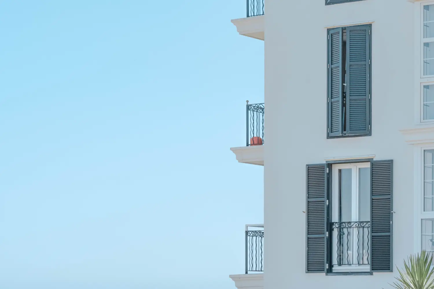 Ferry to Mahon - White building with many floors. Balconies overlook the blue sky. Large side windows.