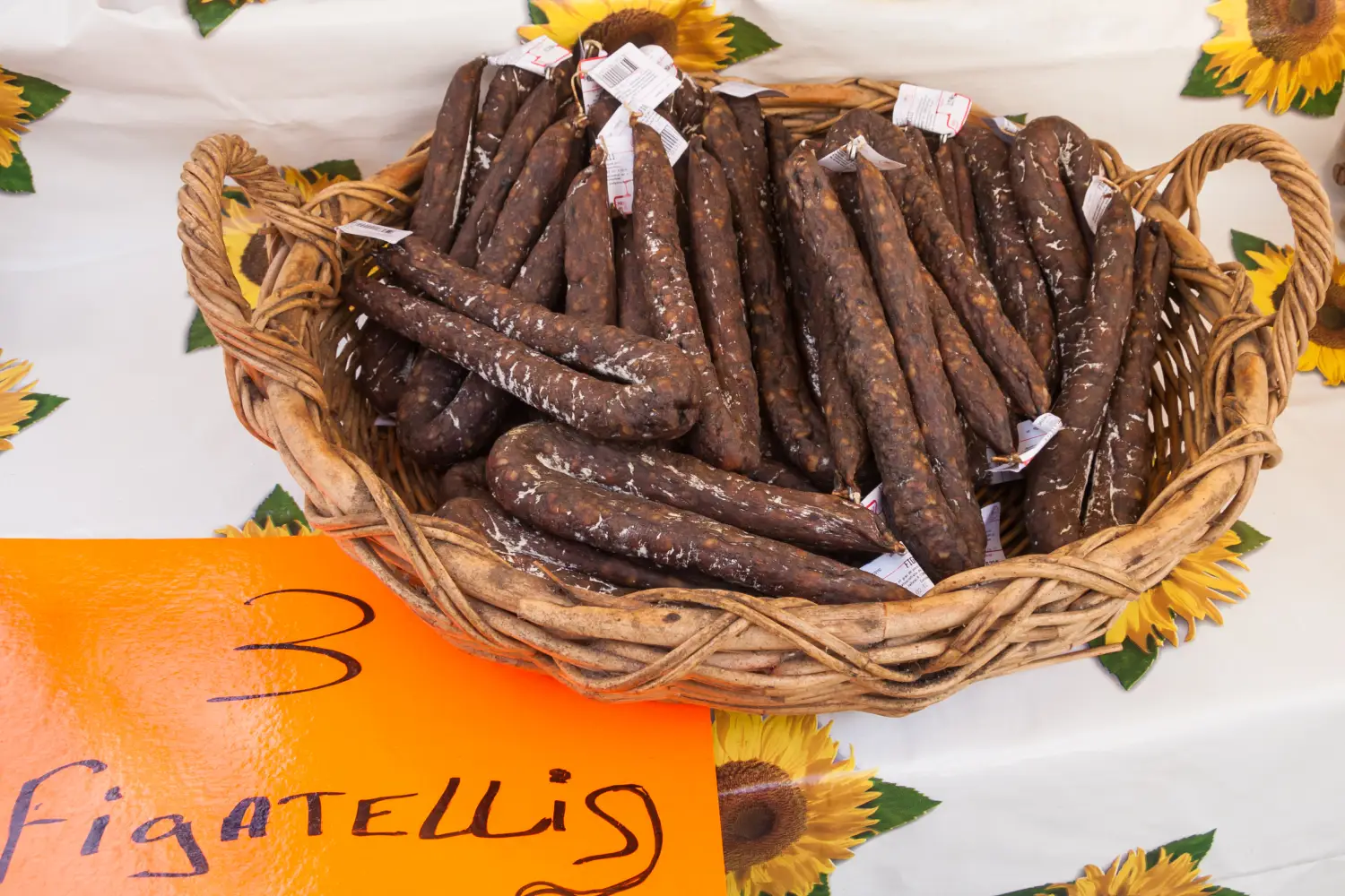 Ferry to Bastia - Corsican specialty figatelli sausage in a basket for sale at a market in Bastia, Corsica, France. Translation for the sign is the type of sausage in Corsican language.