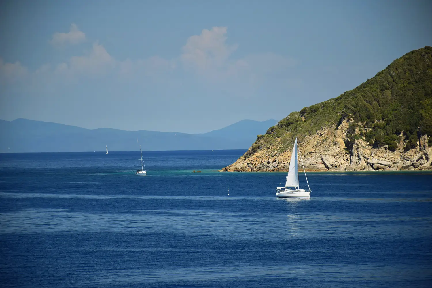 Ferry to Cavo - Sail boat rounding the north west promontory of Elba Island, Italy.