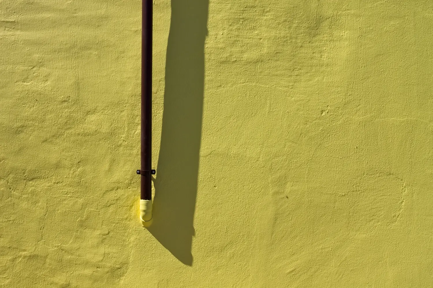 Ferry to Pesaro - A small brown pipe hooked to a yellow wall (Pesaro, Italy, Europe).