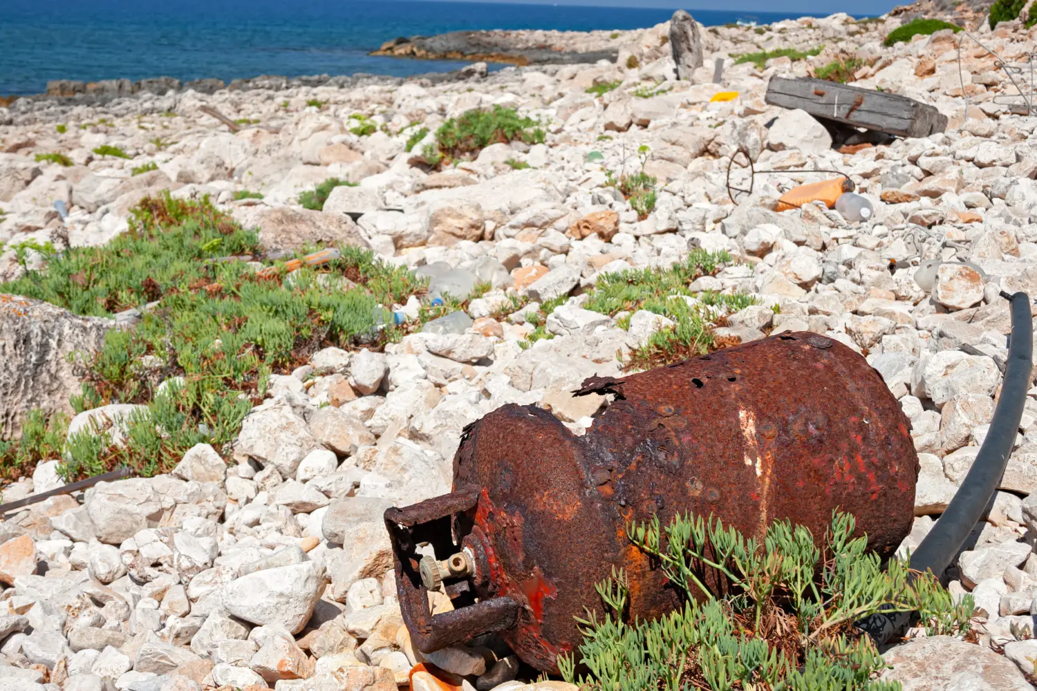 Ferry to Levanzo - Abandoned waste on the rocky coast of the island of Levanzo in Sicily, Italy.