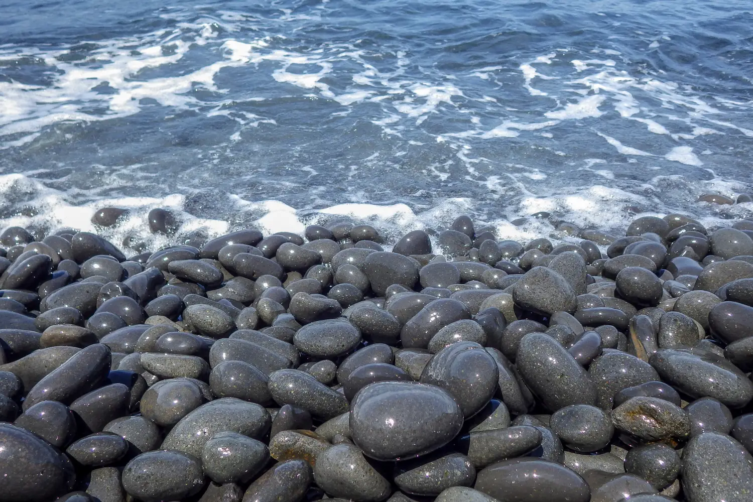 Ferry to Nisyros - The black pebble beach of the island of Nisyros Greece.