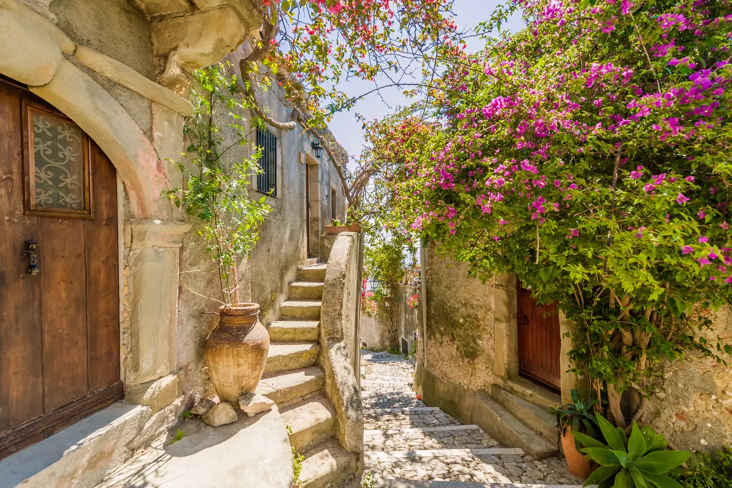 Ferry to Lipari - Fancy flower decorated narrow sunny street with stairs in old town in summer sunshine, Sicily, Italy.