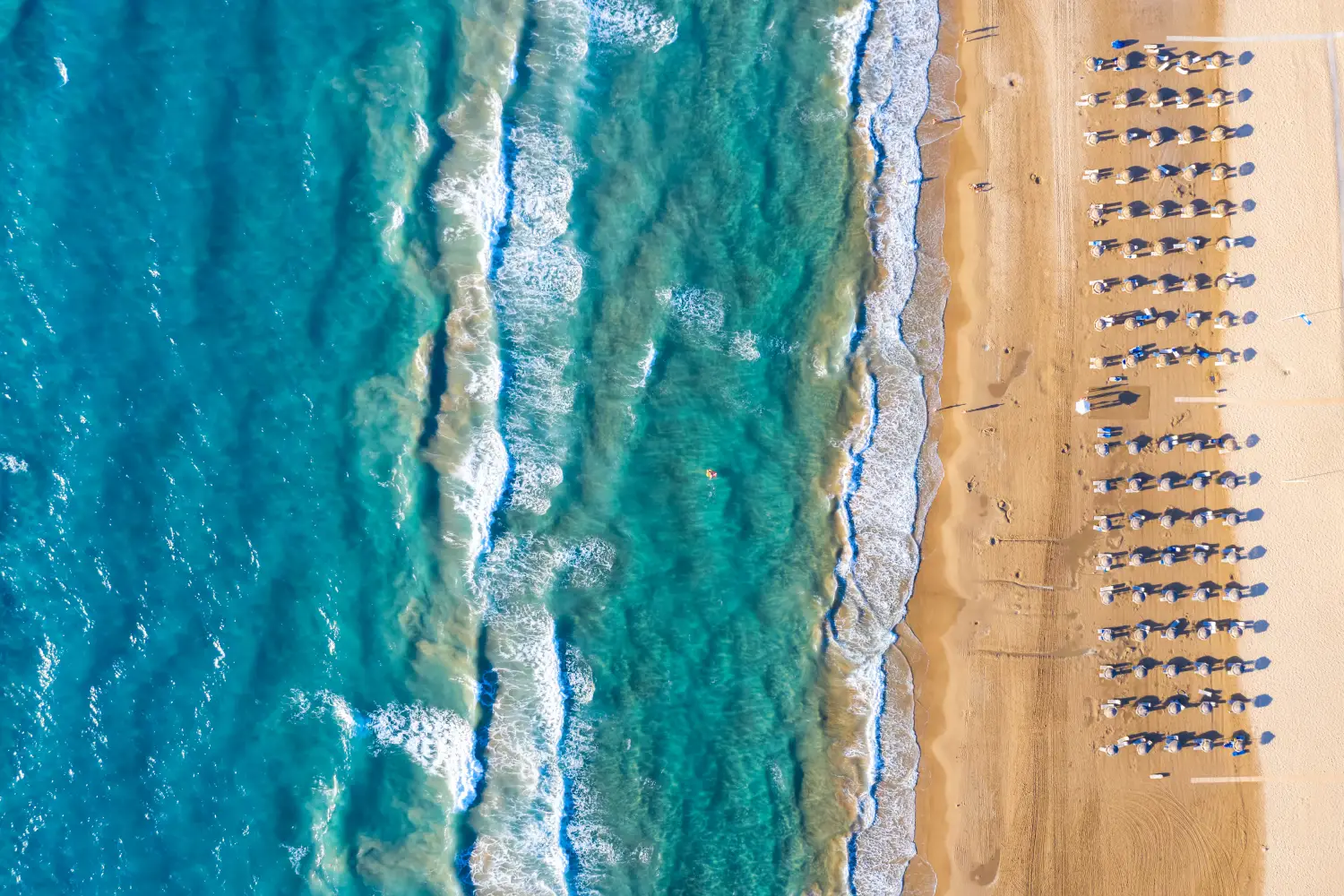 Ferry to Kyllini - Aerial top down view to the beautiful beach of Kyllini, West Peloponnese, Greece, with umbrellas in the golden sand.