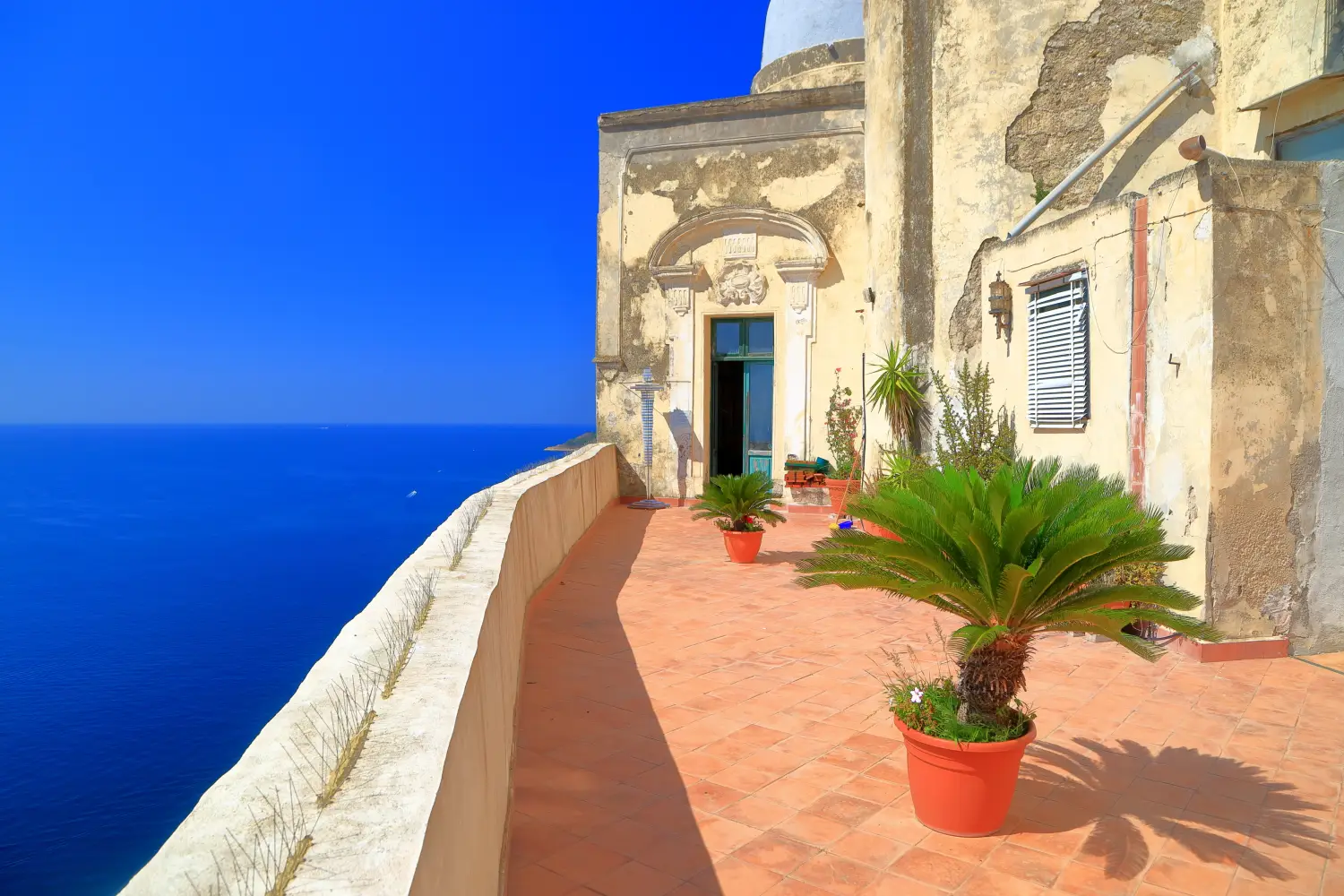 Ferry to Rio Marina - Sunny terrace of the Abbey of St. Michael (Abbazia di San Michele) high above the sea on the island of Procida, Italy.