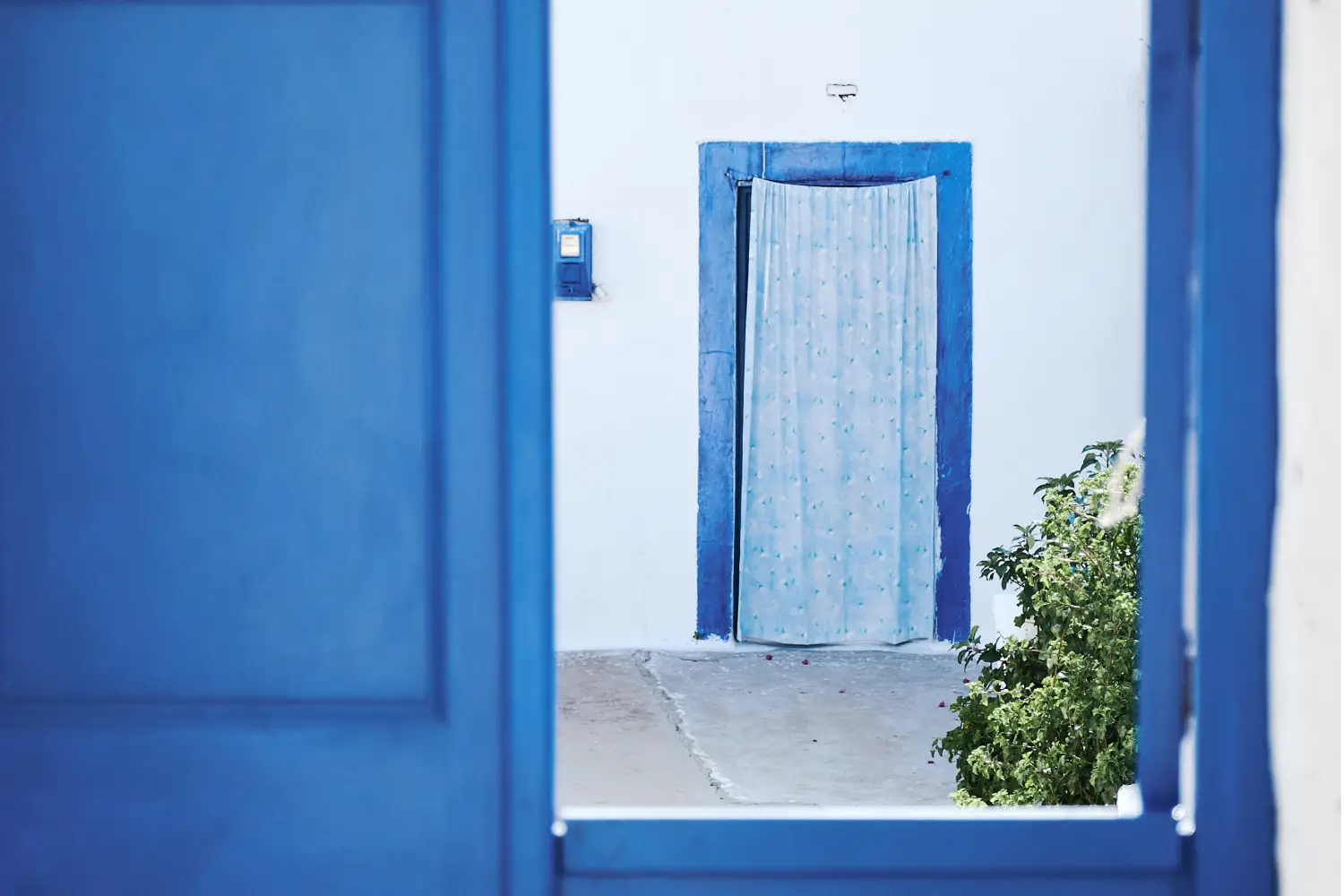 Ferry to Aegiali Amorgos - View from inside a traditional Cycladic Greek house to another ones blue open door.